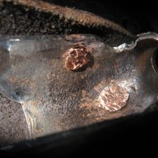 three rivets connecting chrome nose piece to leather